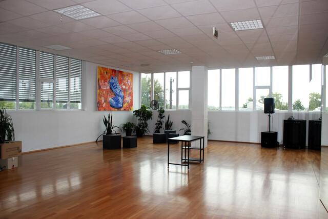 Veranstaltungsraum mir großer Fensterfront und Parkettboden
