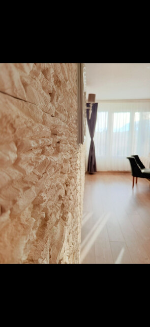 Renoviertes Dachgeschoss Wohnung mit Natursteinwände und Retrostilem Laminatboden, große Panoramaterasse mit atemberaubendem Bergaussicht. 